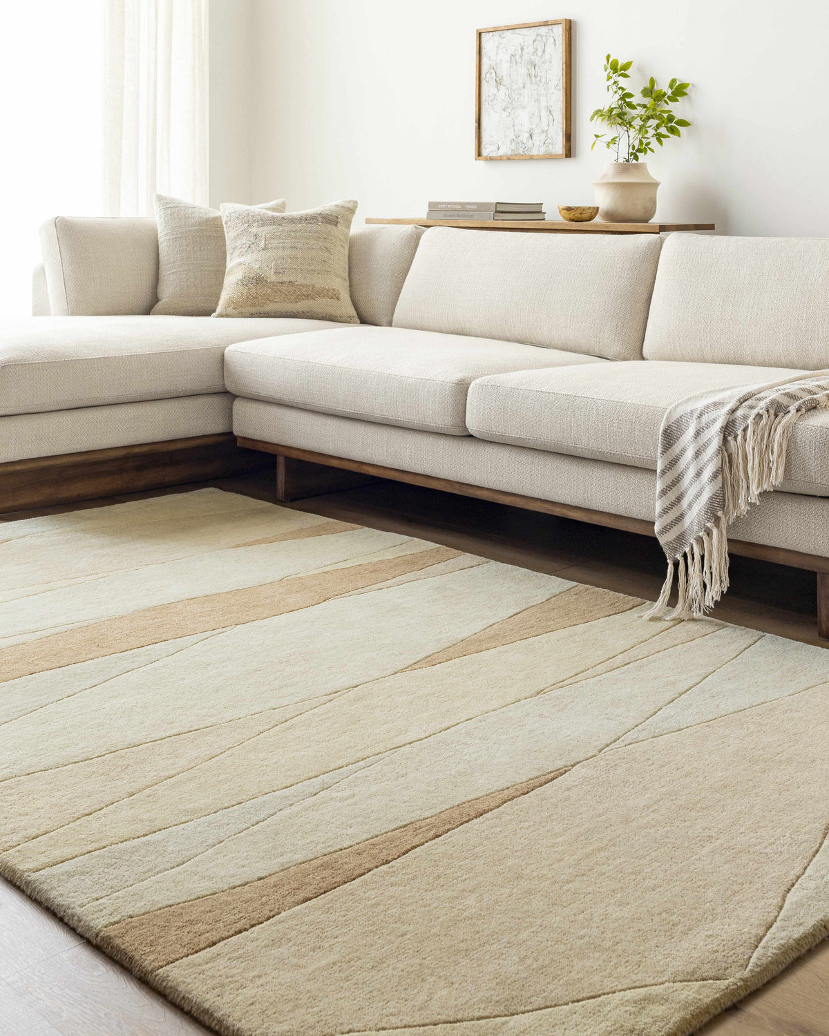 Living room scene with a caramel and cream Robin Modern Wool Rug under a sectional sofa. Roomscene-Rectangle