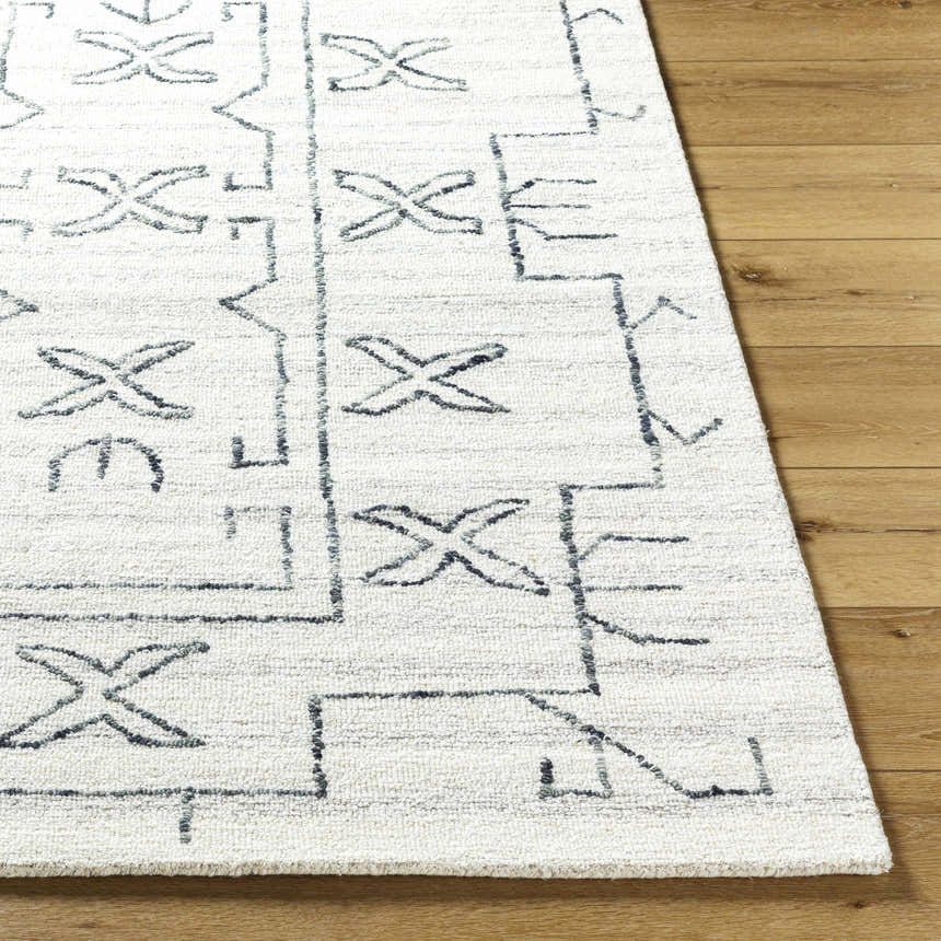 Close up of the Rider Area Rug, a hand-tufted wool rug with a light silver and off-white geometric design. Front