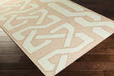 Close-up of the Rhodell Area Rug, a hand-woven wool rug with a geometric pattern in gray, light beige, and seafoam. Corner