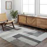 Living room scene with a Raisa Area Rug in gray geometric pattern, wood floors, and mid-century modern furniture. Roomscene-Rectangle
