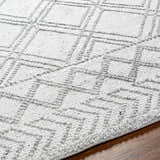 Close-up of the Rena Area Rug showing its arctic stone and gray geometric pattern and hand-woven texture. Texture