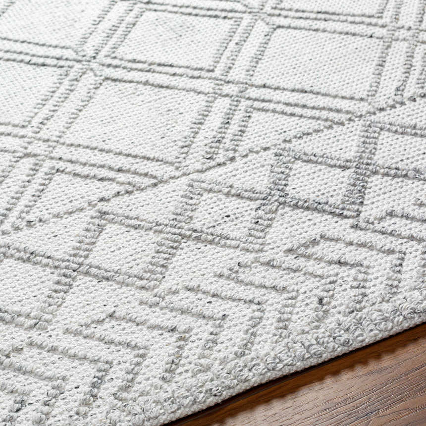 Close-up of the Rena Area Rug showing its arctic stone and gray geometric pattern and hand-woven texture. Texture