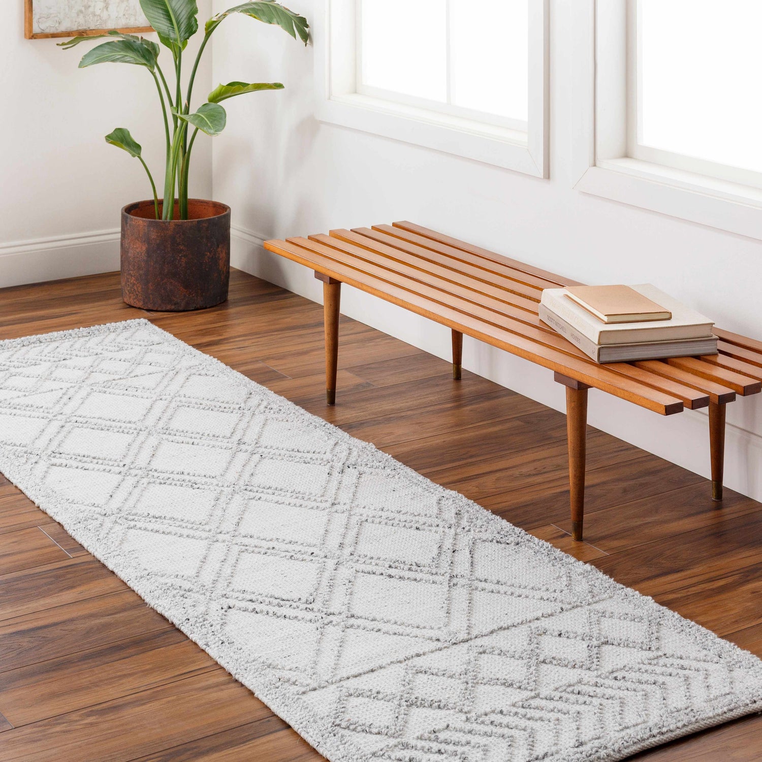 Entryway with gray Rena Area Rug runner, wood bench, books, and plant. Roomscene-Runner