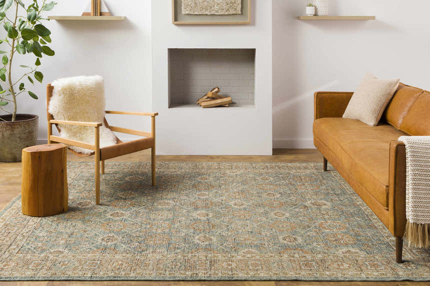 Living room scene with a brown leather sofa and the Rockton Area Rug in sage, beige, and brown tones. Roomscene-Rectangle