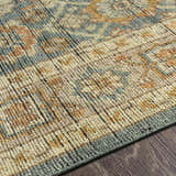 Close-up of the Rockton Area Rug, showcasing its hand-knotted texture, and traditional pattern in black, brown, sage, and beige. Texture