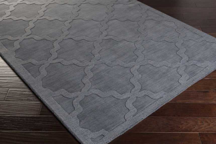 Close-up of the gray Ropesville Wool Area Rug showing its geometric trellis pattern and hand-loomed texture. Corner