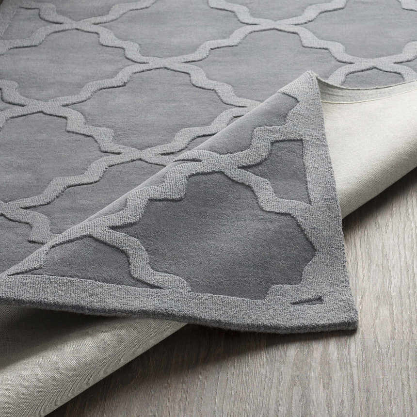 Close up of the gray Ropesville Wool Area Rug showing the geometric trellis pattern and hand loomed texture. Fold