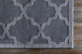 Close-up of the gray Ropesville Wool Area Rug showing its contemporary quatrefoil pattern and hand-loomed texture. Corner