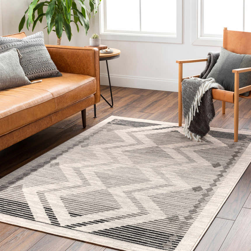 Living room scene with a tan leather sofa and the geometric gray Rory Area Rug. Roomscene-Rectangle