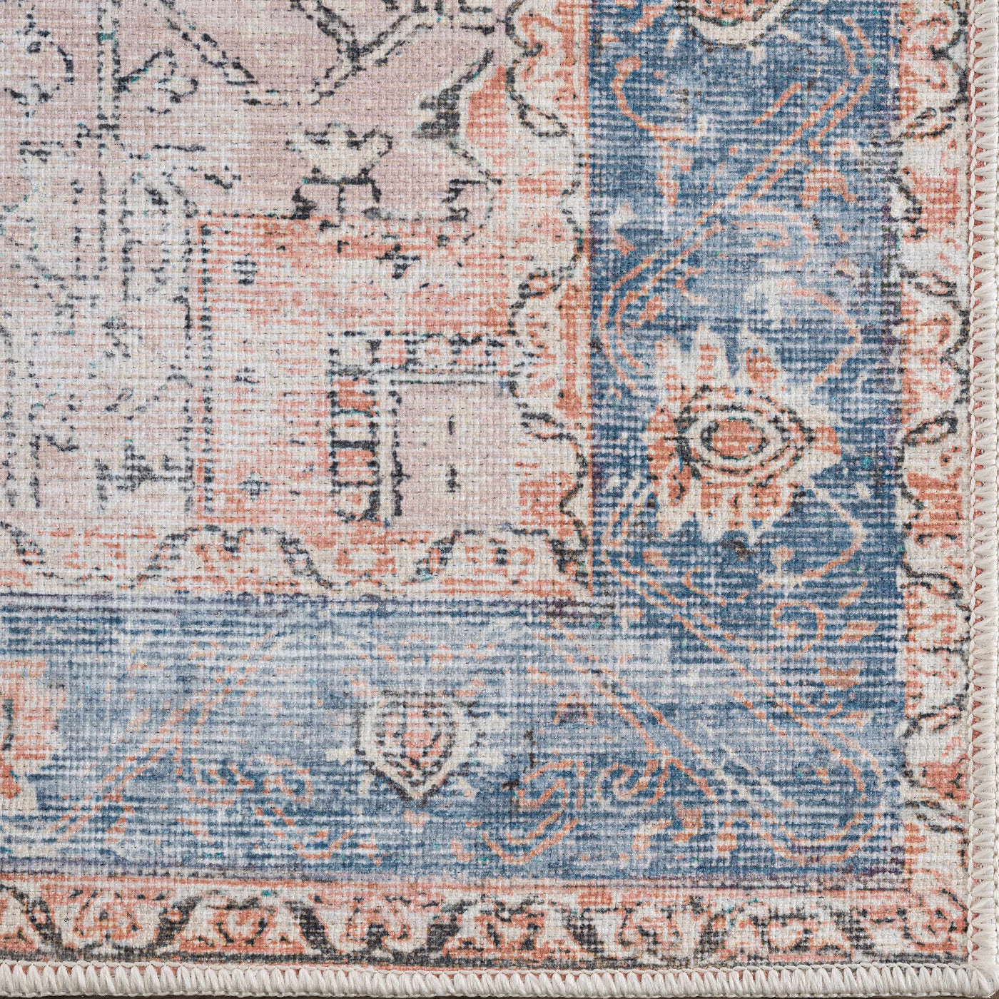 Close-up of the Rosman Distressed Washable Area Rug, showing a traditional pattern in beige, blue, and brick red tones. Swatch