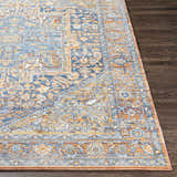 Close-up of the Ripponlea Area Rug showing its traditional design in brick red, navy, and saffron on a dark wood floor. Front