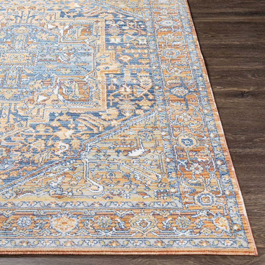 Close-up of the Ripponlea Area Rug showing its traditional design in brick red, navy, and saffron on a dark wood floor. Front