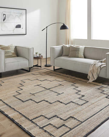 Living room with a tan Robyn Handmade Jute Carpet, light gray sofa and chairs, and black accents. Roomscene-Rectangle