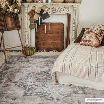 Bedroom scene with a beige and gray Fatih Tumble Dry Washable Rug, bed, fireplace, and fall decor. Roomscene-Rectangle