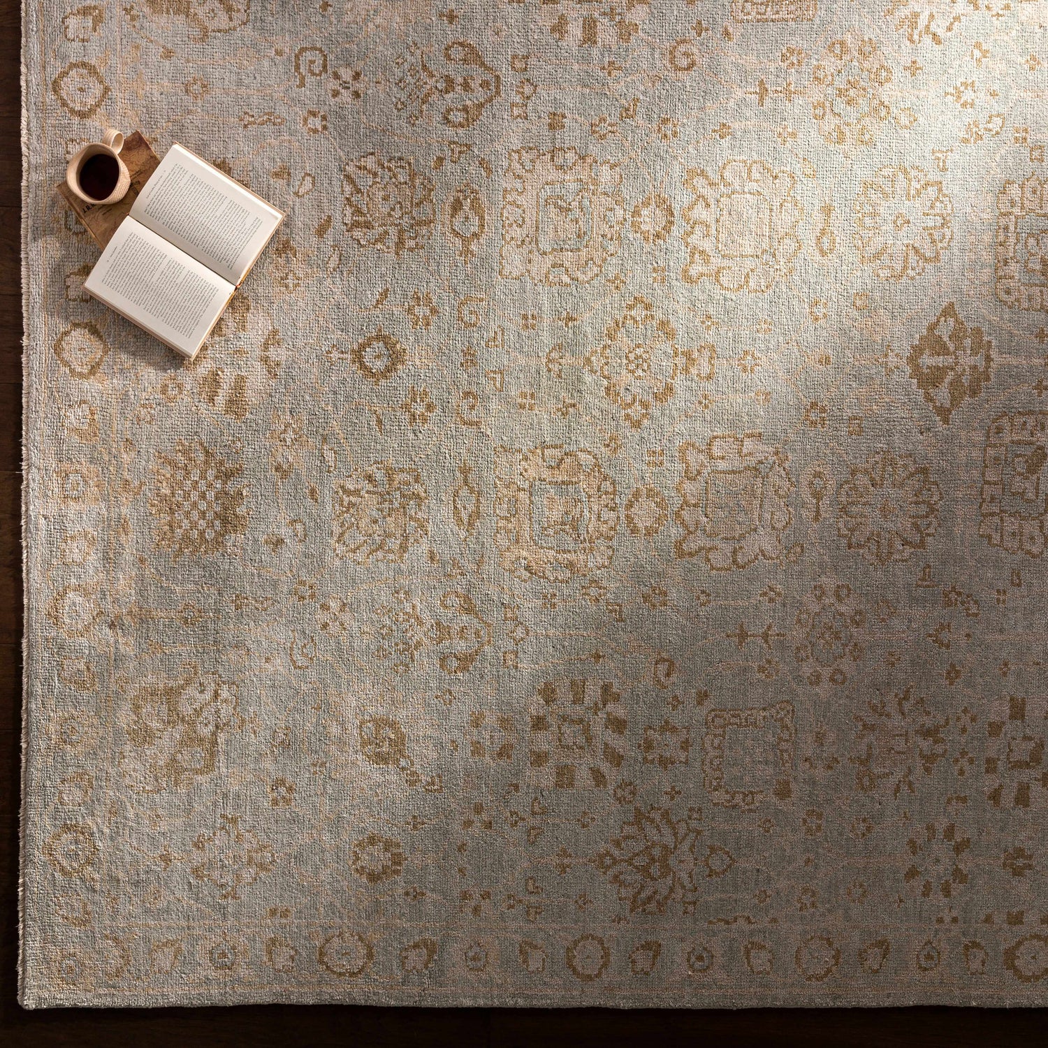 Close-up of the hand-knotted Ravenshead Area Rug in dusty sage and beige with traditional oriental pattern. Styleshot