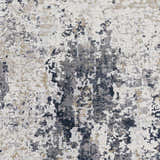 Close-up of the Ryhill Textured Luxe Area Rug showing charcoal, dark blue, beige, and gray abstract pattern. Swatch