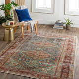 Living room scene with traditional Rio Washable Area Rug in red, blue, and beige. Farmhouse style with chair, plants, and wood floors. Roomscene-Rectangle