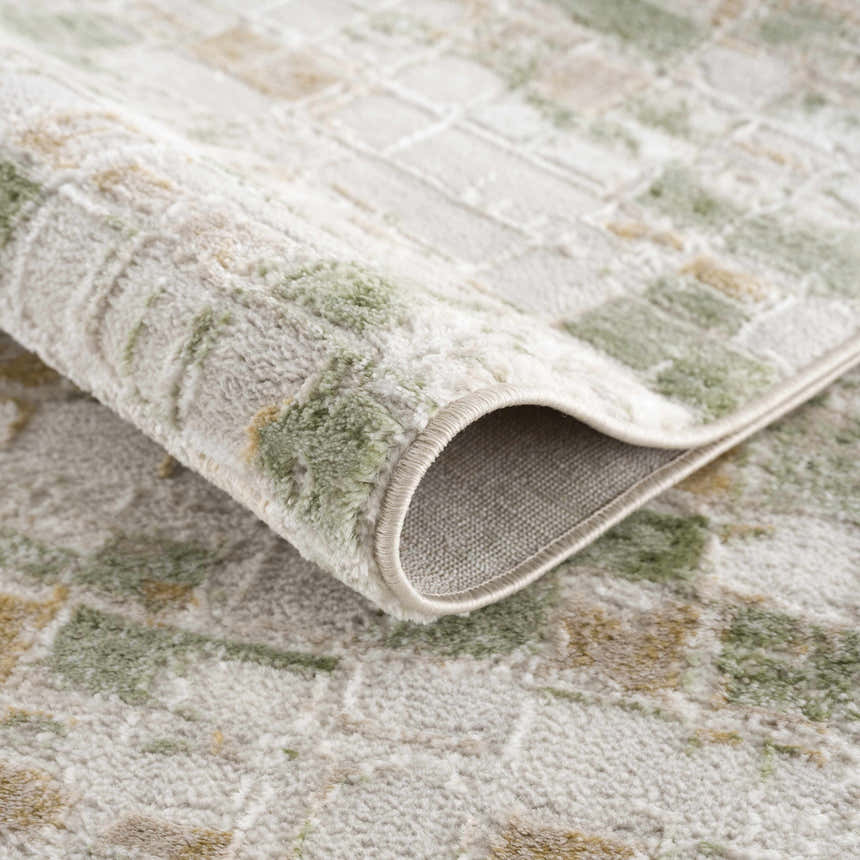 Close-up of the Liveri Green Mosaic Rug showing its abstract pattern, soft texture, and woven construction. Fold
