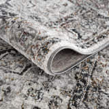 Close-up of the Liverpool Dark Gray Area Rug showing its textured, abstract design and charcoal, rust, and gray colors. Fold