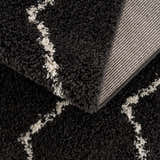 Close-up of the Ennis Area Rug, a charcoal shag rug with a light beige Berber pattern and woven backing. Fold