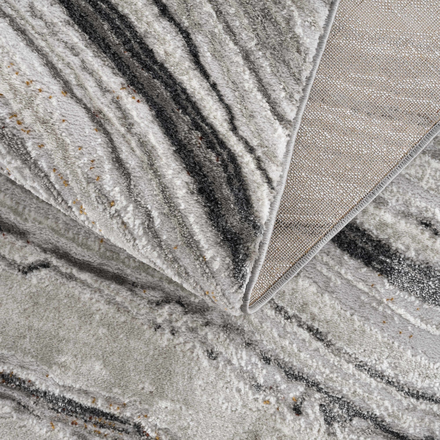 Close-up of the Live Marble Dark Gray Area Rug showing its charcoal, gray, and off-white marble-like pattern and woven texture. Fold