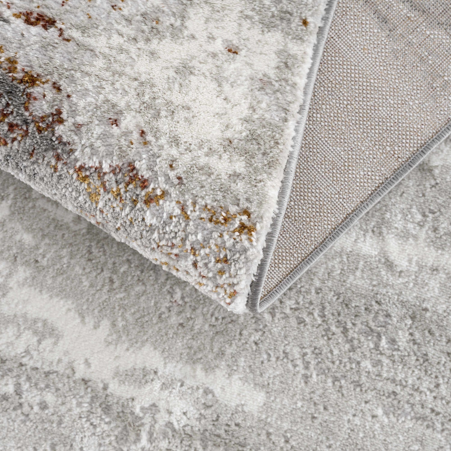 Close-up of the Live Marble Gray Area Rug, showing its charcoal, light gray, rust colors, and machine-woven texture. Fold