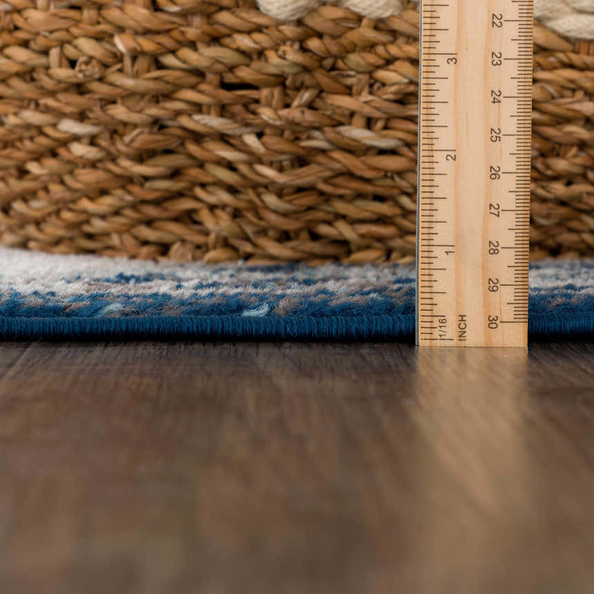 Close-up of the pile height of the Istanbul Blue Area Rug, showing ivory and navy fibers with a ruler for scale. Pile