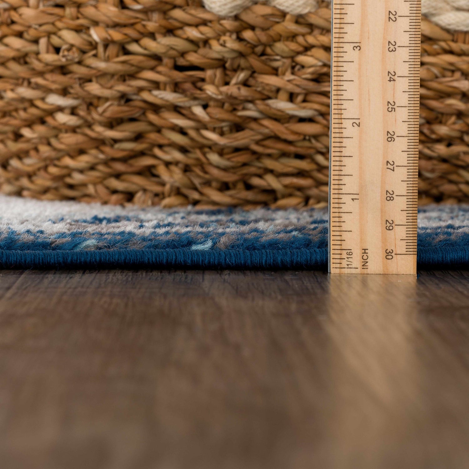 Close-up of the pile height of the Istanbul Blue Area Rug, showing ivory and navy fibers with a ruler for scale. Pile
