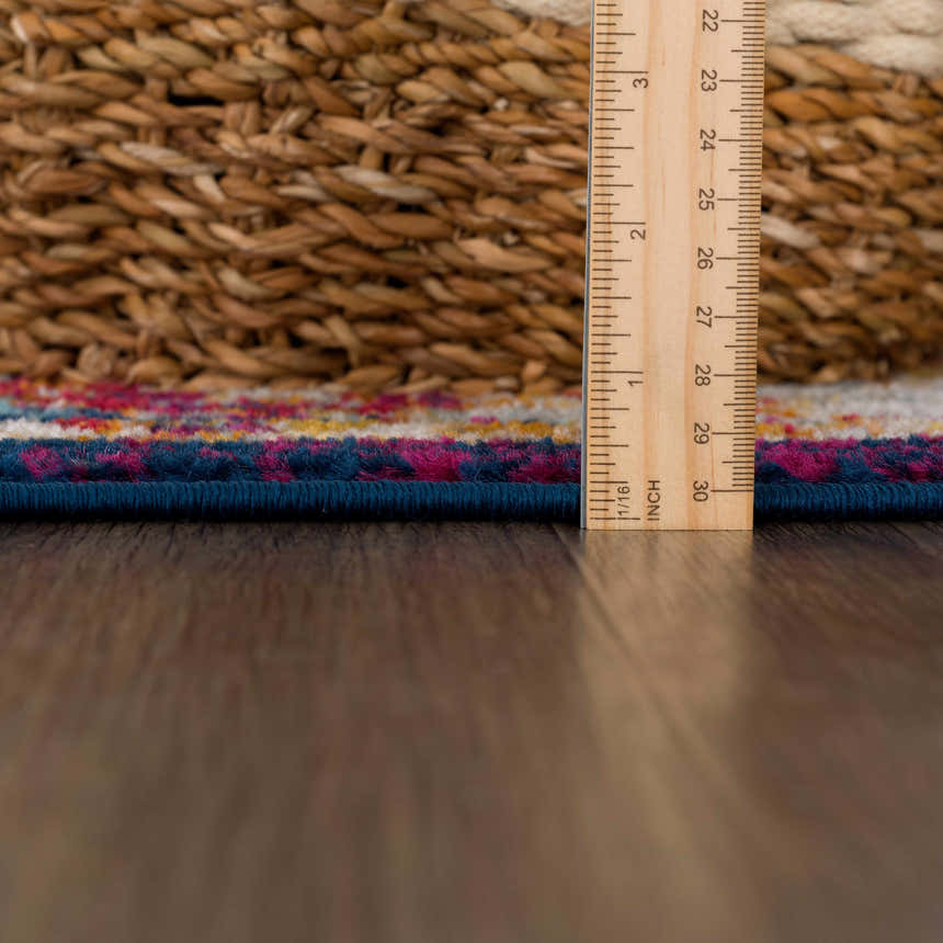 Close-up of the Istanbul Vintage Navy Area Rug showing the rug's texture, navy border, and colorful pattern. Pile