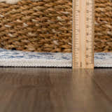 Close-up of Michie Blue Area Rug showing thickness with ruler, plus woven texture and blue and white pattern. Pile