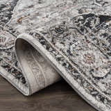 Close-up of the Liverpool Dark Gray Area Rug showing its charcoal, gray, rust, and off-white traditional pattern. Fold