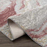 Close-up of Lively Marble Pink Area Rug showing pink, gray, and mustard marble pattern and woven texture. Fold