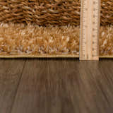 Close-up of Heavenly Solid Mustard Plush Rug showing its thick shag pile and construction, with a ruler for scale. Pile
