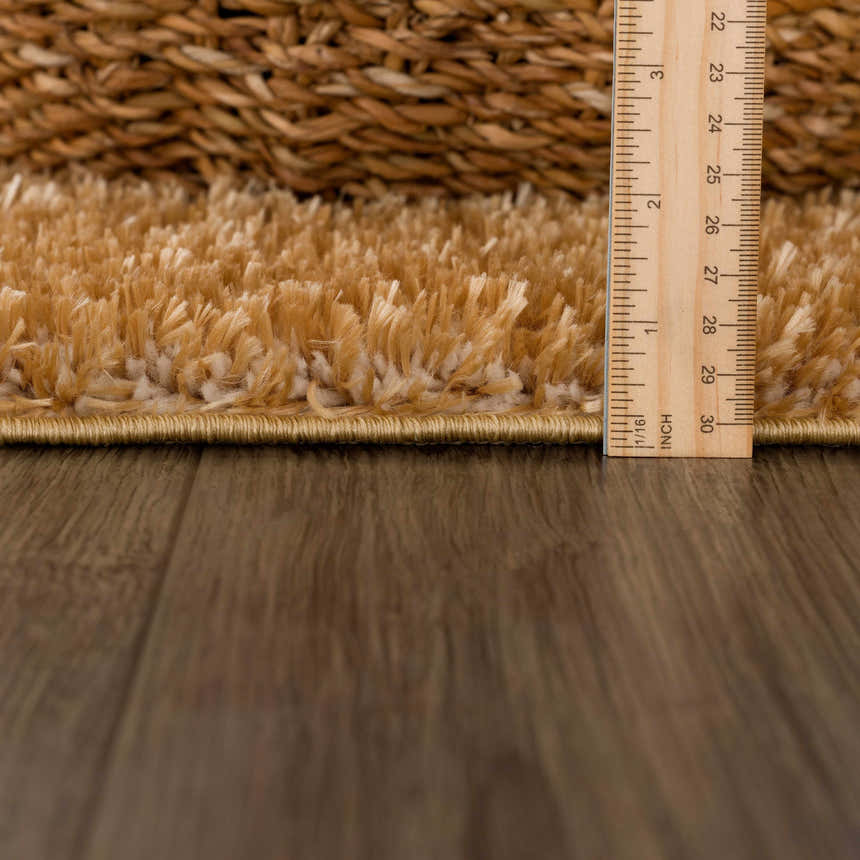 Close-up of Heavenly Solid Mustard Plush Rug showing its thick shag pile and construction, with a ruler for scale. Pile