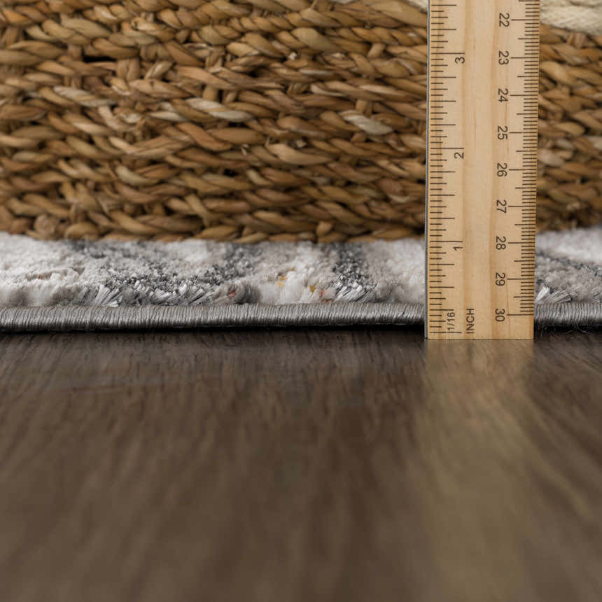 Close-up of the Live Marble Dark Gray Area Rug showing rug thickness with ruler and woven texture. Pile