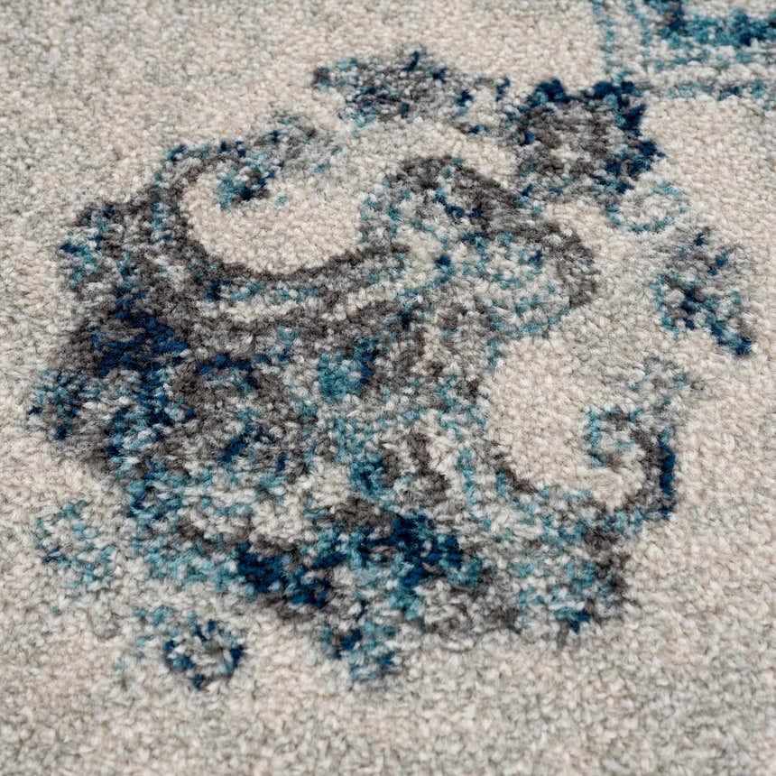 Close-up of the Istanbul Blue Area Rug showing its ivory base and navy, gray, and light blue floral pattern. Texture