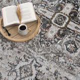 Close-up of the Liverpool Dark Gray Area Rug with a book, coffee, and decorative sprig on a wooden tray. Styleshot