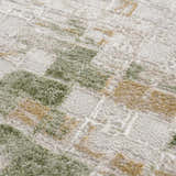 Close-up of the Liveri Green Mosaic Rug. Abstract pattern with green, beige, and ivory hues. Soft, textured weave. Texture