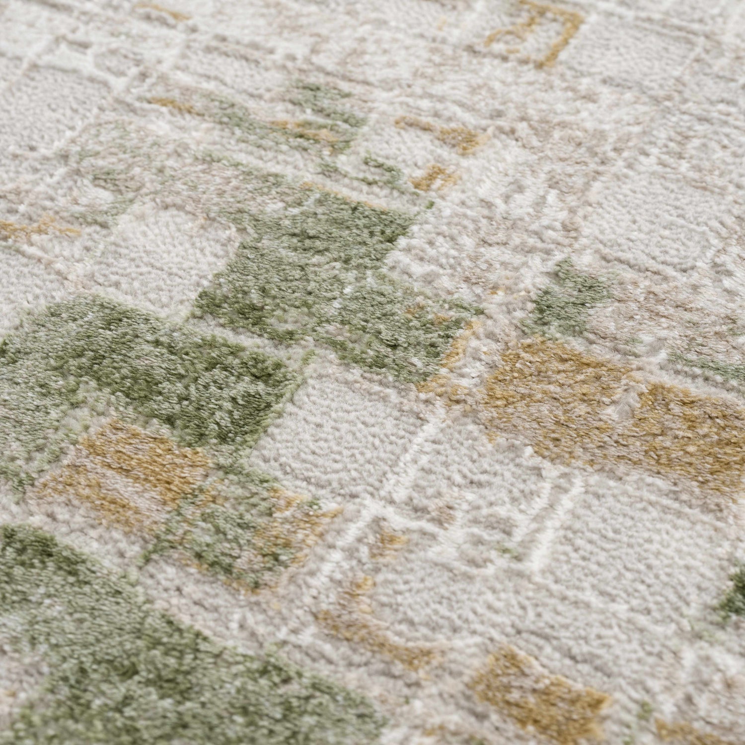 Close-up of the Liveri Green Mosaic Rug. Abstract pattern with green, beige, and ivory hues. Soft, textured weave. Texture