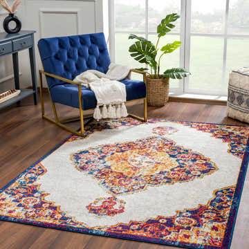 Living room scene with a blue velvet chair and the Istanbul Orange Area Rug, a colorful bohemian accent. Roomscene-Rectangle