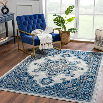 Living room scene with Istanbul Medallion Blue Area Rug, blue velvet chair, console table, and natural light from a large window. Roomscene-Rectangle