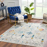Living room scene with a blue chair and the Istanbul Aztec Area Rug featuring colorful geometric patterns. Roomscene-Rectangle