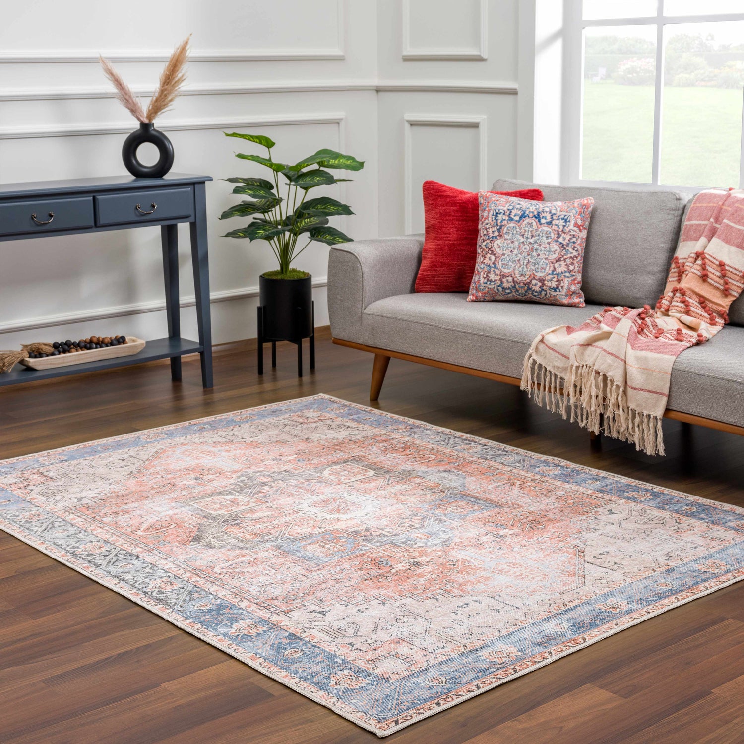 Living room with gray sofa, blue console table, and Rosman Distressed Washable Area Rug in beige, blue, and brick red. Roomscene-Rectangle