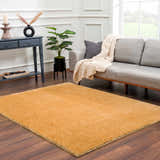 Living room scene with gray sofa and the Heavenly Solid Mustard Plush Rug on dark wood floors. Roomscene-Rectangle