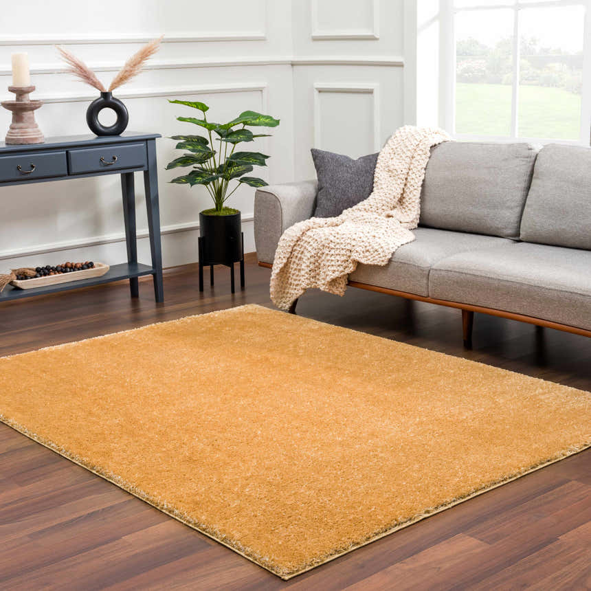 Living room scene with gray sofa and the Heavenly Solid Mustard Plush Rug on dark wood floors. Roomscene-Rectangle