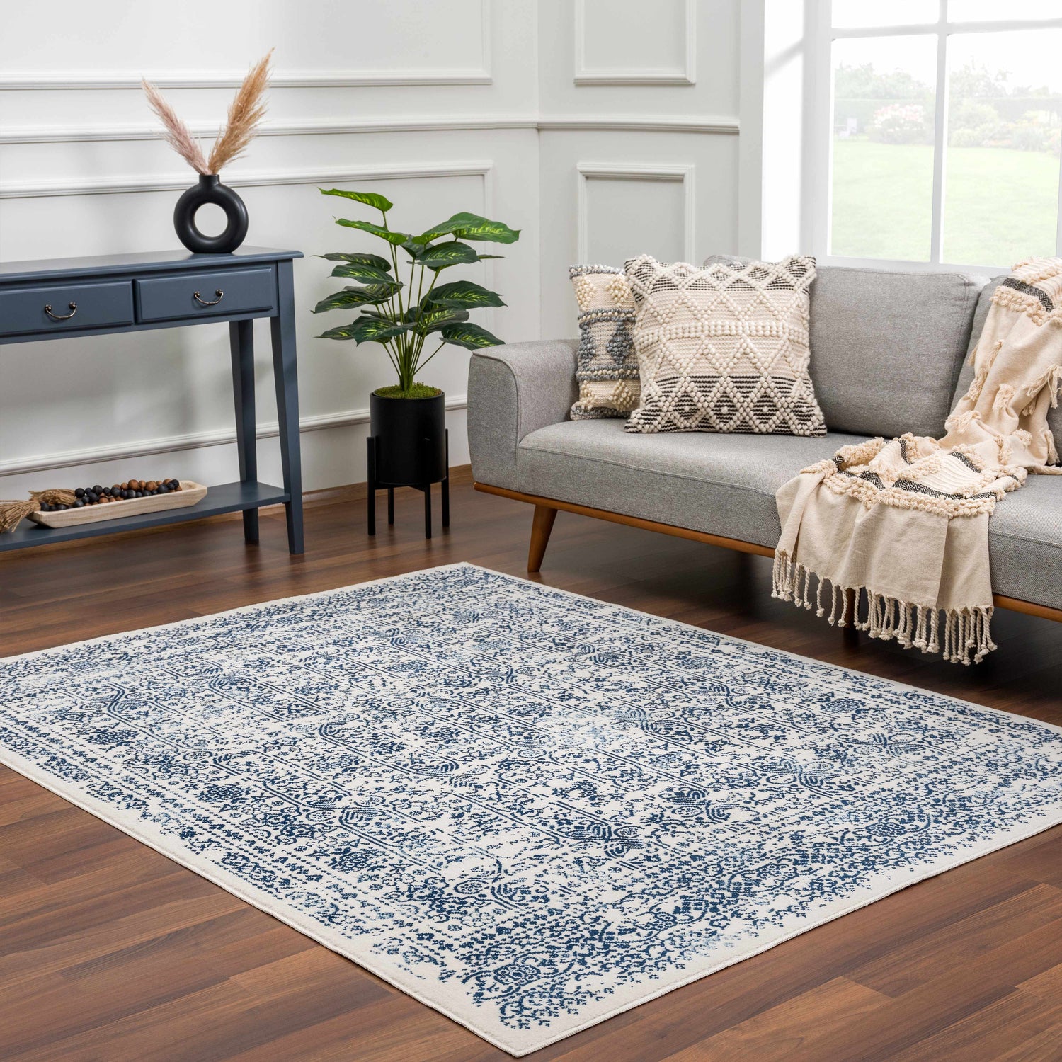 Living room scene with a blue and white Michie Blue Area Rug, gray sofa, and blue console table. Roomscene-Rectangle