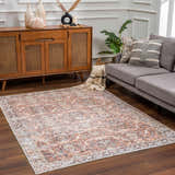 Living room scene with a Bian Washable Area Rug in peach, beige, and blue. Farmhouse style with wood cabinet and gray sofa. Roomscene-Rectangle