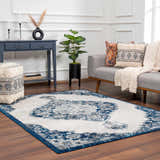Living room scene with an ivory and navy Istanbul Blue Area Rug, gray sofa, and blue console table. Roomscene-Rectangle