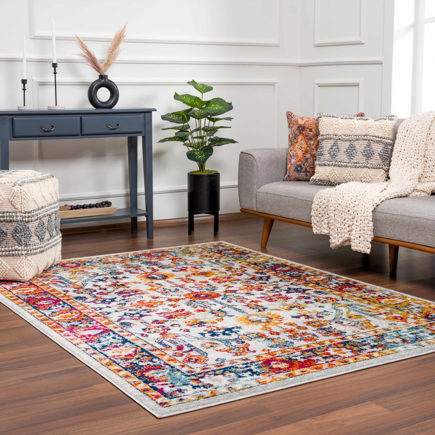 Living room scene with gray sofa and Istanbul Colorful Rug, a vibrant, patterned rug in pink, blue, and mustard tones. Roomscene-Rectangle
