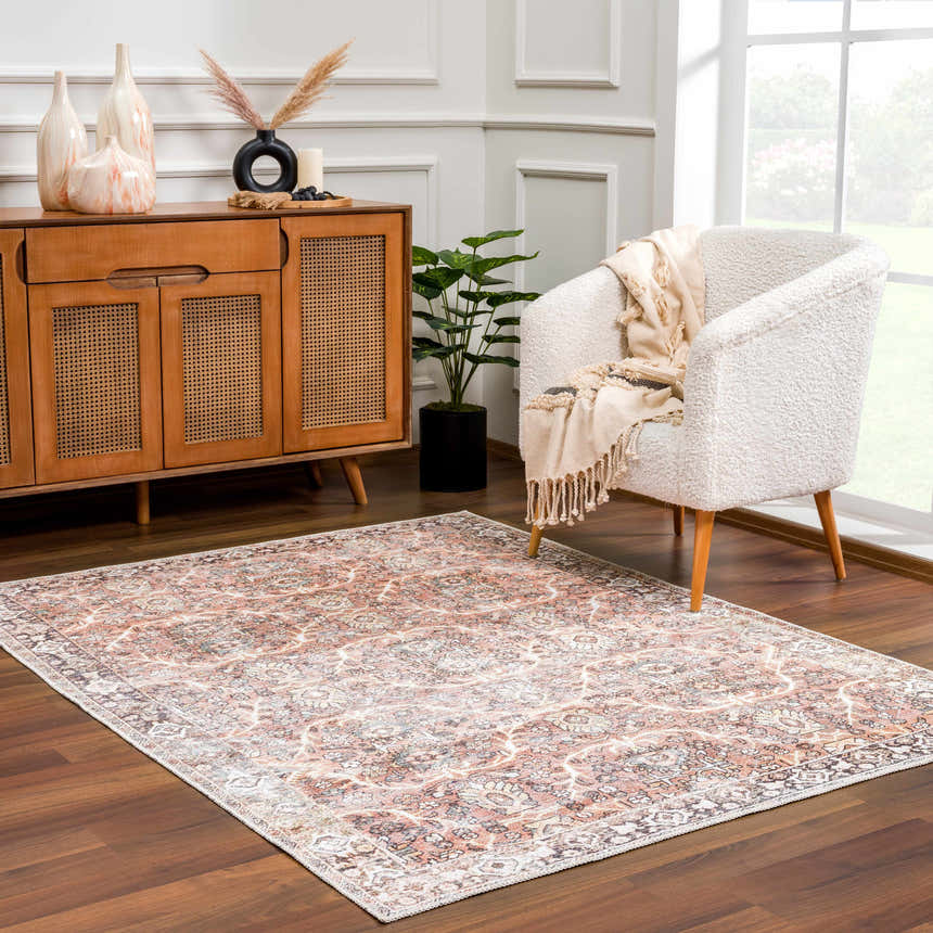 Living room scene with a Bian Washable Area Rug in peach, beige, and brown tones, styled with a white chair and wood cabinet. Roomscene-Rectangle